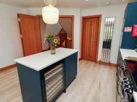 A kitchen with a central island and a wine cooler at Alma House in Seahouses