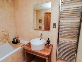 A bathroom with a bathtub and sink at Alma House Seahouses