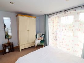 A bedroom with furniture and window at Alma House in Seahouses