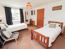 A bedroom with two beds and a chair at Alma House in Seahouses