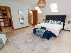 A bedroom with a bed and mirror at Alma House in Seahouses