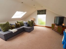 A living room with a sofa and tv at Alma House Seahouses
