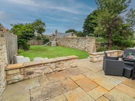 A garden with a slide and seating area at Alma House in Seahouses