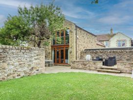 A patio area with seating and lawn at Alma House in Seahouses