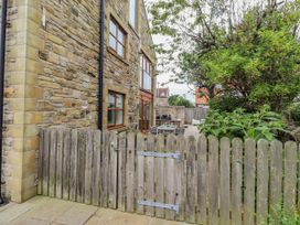 An outdoor area with a stone wall and wooden fence at Alma House in Seahouses