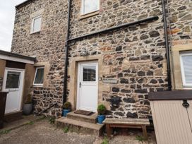 An outdoor view of a stone wall with a door and window at The Granary