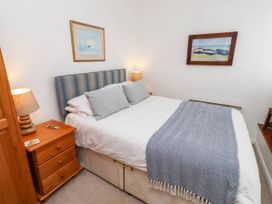 A bedroom with a bed and bedside table at Spinnaker
