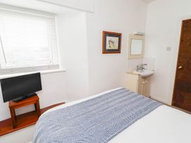 A bedroom with a bed, television, and sink at Spinnaker