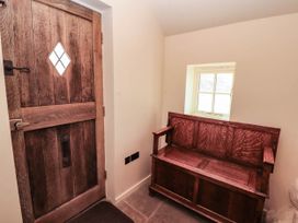 A hallway with a wooden door and a bench at Claybottom Farm near Hesket Newmarket