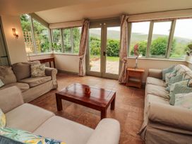 A conservatory with seating and a coffee table at Claybottom Farm near Hesket Newmarket