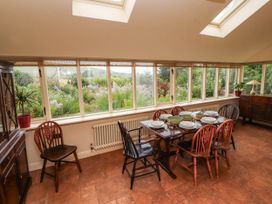 A conservatory with a dining table and chairs at Claybottom Farm near Hesket Newmarket