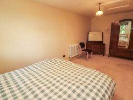 A bedroom with a bed, chair, and wardrobe at Claybottom Farm near Hesket Newmarket