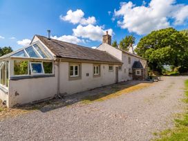 A house with a conservatory and pathway at Claybottom Farm in Hesket Newmarket