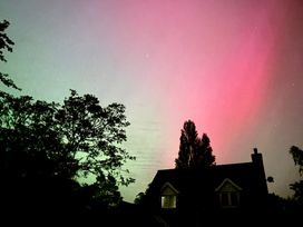 A sky with aurora colors over a house at Fables Cottage, Otley, Suffolk