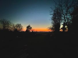 A sunset view with trees in the foreground at Fables Cottage Otley, Suffolk
