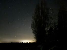 A night sky filled with stars and trees at Fables Cottage, Otley, Suffolk