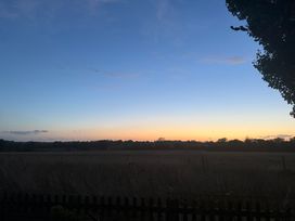 A landscape view of a field during sunset at Fables Cottage in Otley, Suffolk