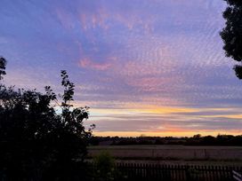 A sunset view with clouds and silhouettes of trees at Fables Cottage Otley, Suffolk