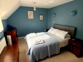 A bedroom with a bed and nightstands at Fables Cottage in Otley, Suffolk