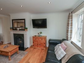A living room with a fireplace and a television at The Cosy Haven in Malton