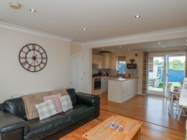 A living room with a sofa and kitchen area at The Cosy Haven in Malton