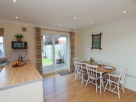 A kitchen with a dining area and sliding door at The Cosy Haven in Malton