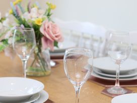 A dining room table set with wine glasses and plates at The Cosy Haven in Malton