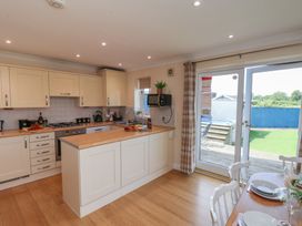 A kitchen with appliances and dining area at The Cosy Haven in Malton