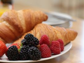 A plate with croissants and assorted berries at The Cosy Haven in Malton