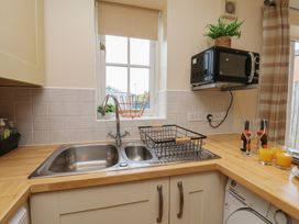 A kitchen with sink and microwave at The Cosy Haven in Malton
