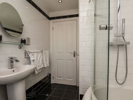A bathroom with a sink, mirror, and shower at The Cosy Haven in Malton