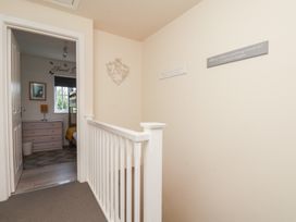 A hallway with a staircase leading to a room with a bed and window at The Cosy Haven in Malton