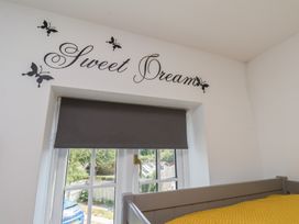 A bedroom with a window and a yellow blanket at The Cosy Haven in Malton