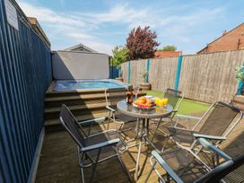 An outdoor area with a hot tub and seating at The Cosy Haven in Malton