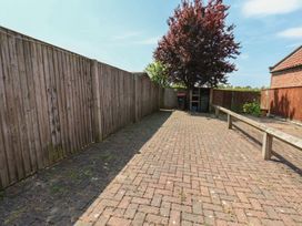 A garden with a tree and benches at The Cosy Haven in Malton