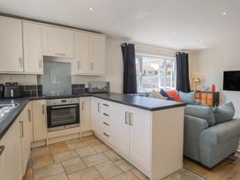 A kitchen with cabinets and a seating area at 2 Mill Green Court in Lyme Regis