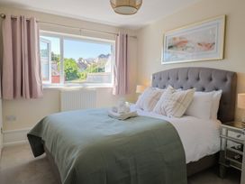 A bedroom with a bed and window at 2 Mill Green Court Lyme Regis