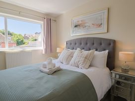 A bedroom with a bed and decorative pillow at 2 Mill Green Court in Lyme Regis