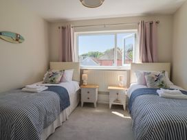 A bedroom with two beds and a window at 2 Mill Green Court Lyme Regis