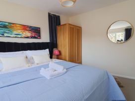A bedroom with a bed and wardrobe at 2 Mill Green Court in Lyme Regis