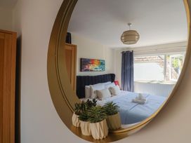 A bedroom with a bed and mirror at 2 Mill Green Court in Lyme Regis