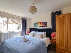 A bedroom with a bed and wardrobe at 2 Mill Green Court in Lyme Regis