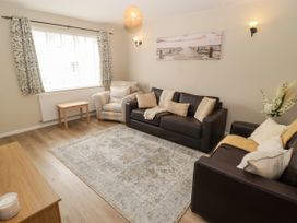 A living room with a sofa and armchair at 7 Cwrt Y Cadno in Llantwit Major