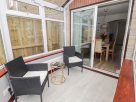 A conservatory with chairs and a table at 7 Cwrt Y Cadno in Llantwit Major