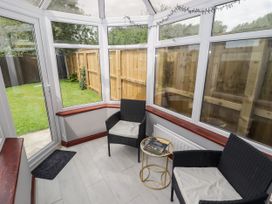 A conservatory with chairs and a small table at 7 Cwrt Y Cadno in Llantwit Major
