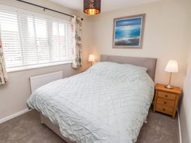 A bedroom with a bed and lamps at 7 Cwrt Y Cadno in Llantwit Major