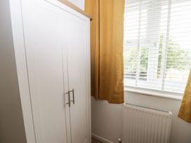 A bedroom with a wardrobe and window at 7 Cwrt Y Cadno Llantwit Major