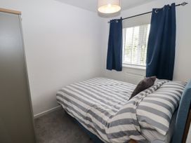 A bedroom with a bed and curtains at 7 Cwrt Y Cadno in Llantwit Major