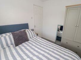 A bedroom with a bed and wardrobe at 7 Cwrt Y Cadno in Llantwit Major
