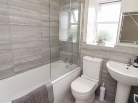A bathroom with a bathtub, shower, toilet, and sink at 7 Cwrt Y Cadno in Llantwit Major